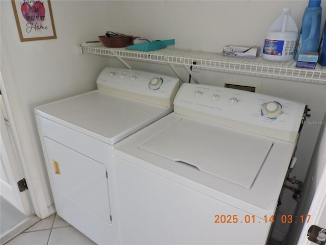 clothes washing area with washing machine and clothes dryer and light tile patterned floors