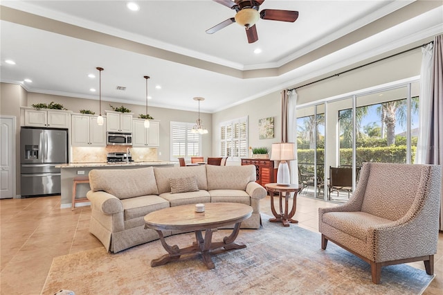 living room featuring ceiling fan, plenty of natural light, and crown molding