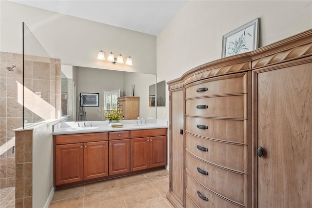 bathroom with tiled shower, vanity, and tile patterned floors