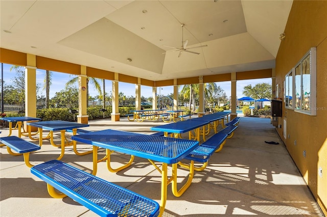 exterior space featuring a raised ceiling, ceiling fan, and plenty of natural light