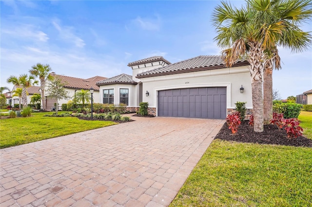 mediterranean / spanish-style home featuring a garage and a front yard