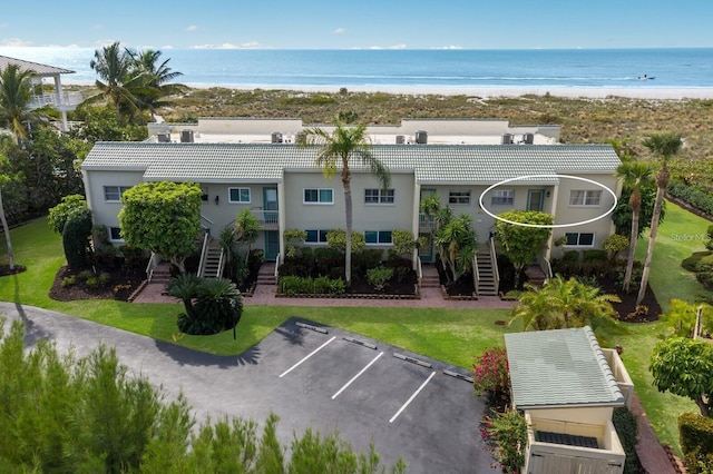 drone / aerial view featuring a water view and a view of the beach