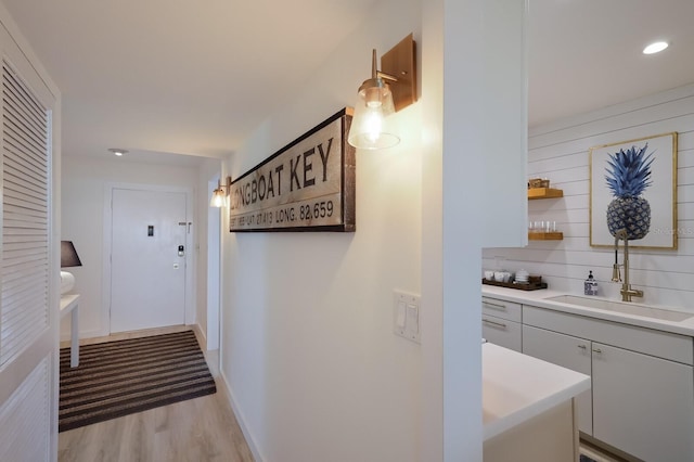 hallway with sink and light wood-type flooring