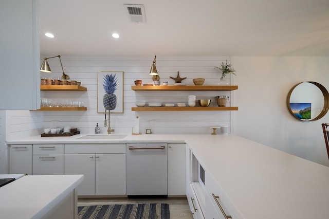 kitchen with decorative backsplash, white dishwasher, dark wood-type flooring, sink, and white cabinets