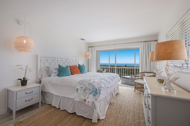 bedroom featuring access to exterior and light wood-type flooring