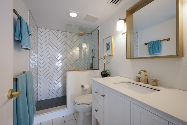 bathroom with tile patterned floors, vanity, toilet, and tiled shower