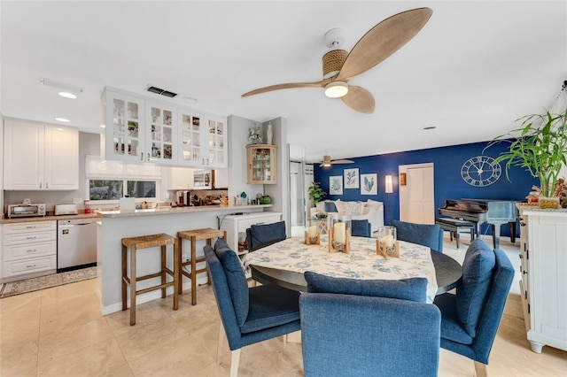 tiled dining space with ceiling fan