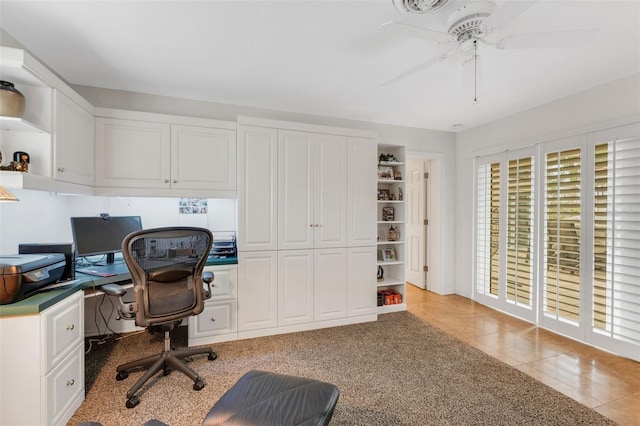 office area featuring built in desk, light tile patterned floors, and ceiling fan