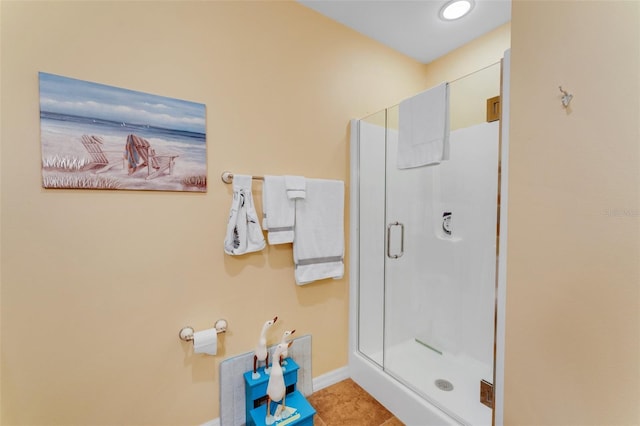 bathroom with a shower with door and tile patterned flooring