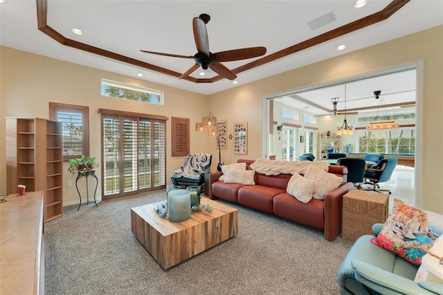 living room with light carpet, a wealth of natural light, ceiling fan, and a tray ceiling