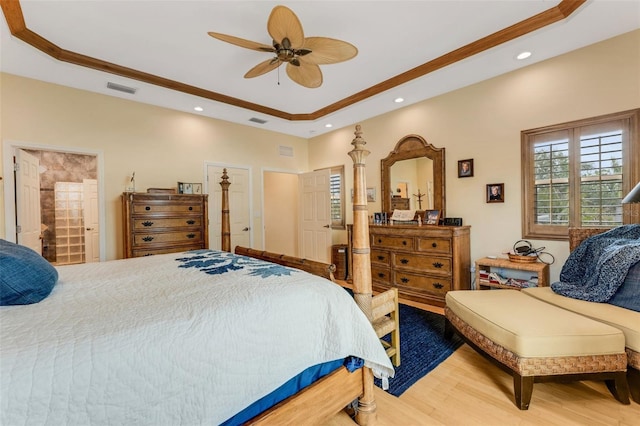 bedroom featuring a tray ceiling, hardwood / wood-style flooring, and ceiling fan