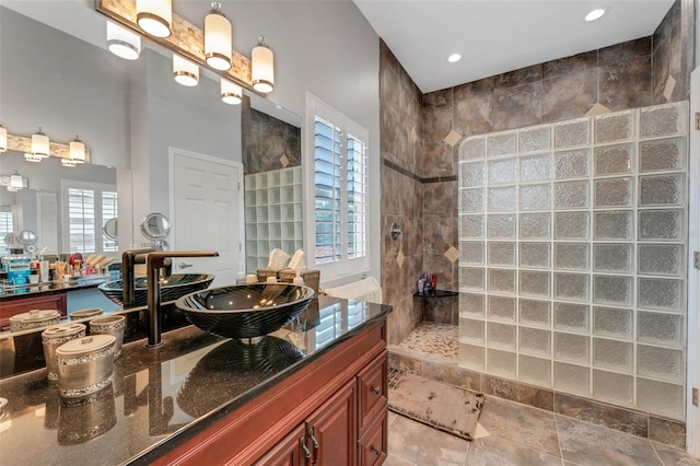 bathroom with tiled shower and vanity