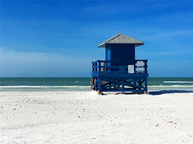 view of property's community with a water view and a beach view