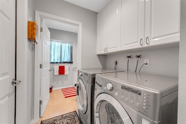 washroom with cabinets, washer and clothes dryer, and light tile patterned floors