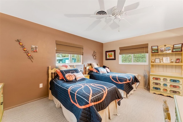 carpeted bedroom featuring multiple windows and ceiling fan