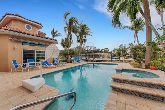 view of swimming pool featuring a pool with connected hot tub and a patio