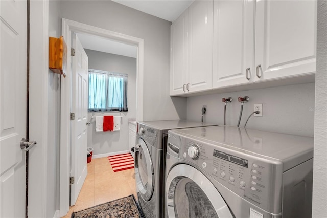 clothes washing area featuring light tile patterned floors, cabinet space, independent washer and dryer, and baseboards
