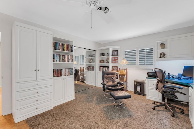 office featuring visible vents, light colored carpet, and a ceiling fan