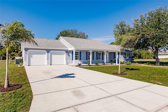 ranch-style house featuring a garage, a front yard, and covered porch