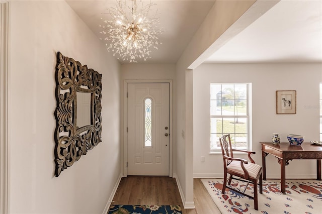 entrance foyer with a chandelier and wood-type flooring