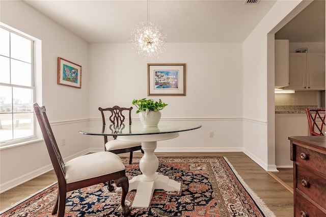 dining space with a notable chandelier and dark hardwood / wood-style flooring