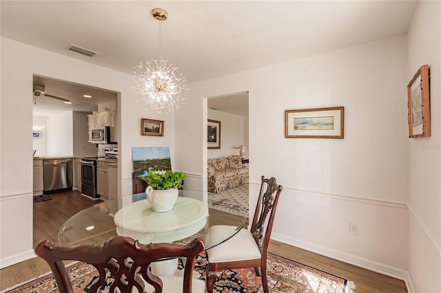 dining room featuring dark hardwood / wood-style floors and an inviting chandelier