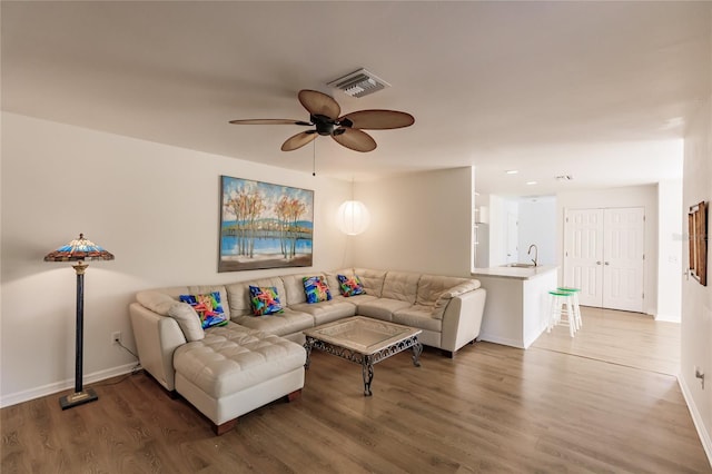 living room with ceiling fan, sink, and dark hardwood / wood-style flooring