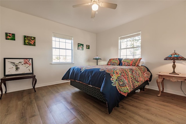 bedroom with ceiling fan, dark hardwood / wood-style floors, and multiple windows