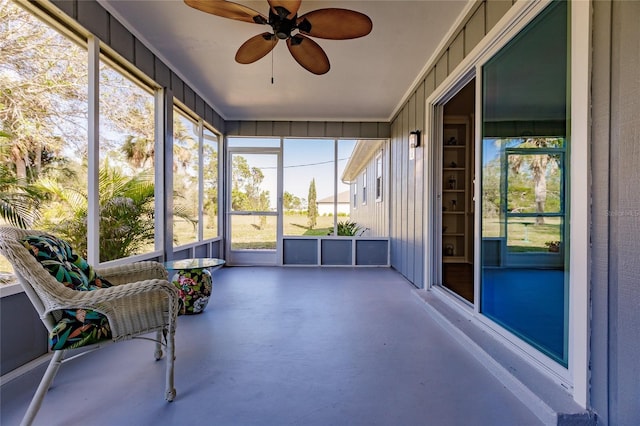 unfurnished sunroom featuring ceiling fan