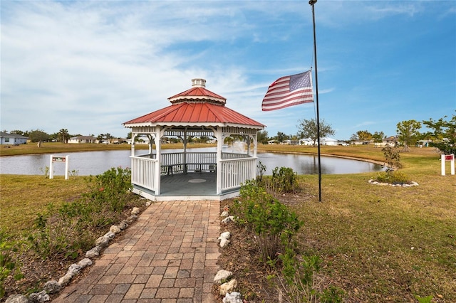 view of dock with a gazebo, a yard, and a water view