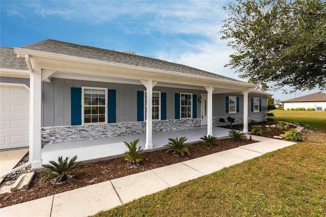 ranch-style home with covered porch and a front yard