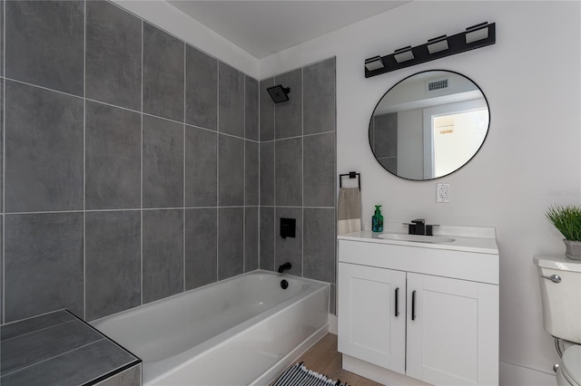 full bathroom with vanity, hardwood / wood-style flooring, toilet, and tiled shower / bath