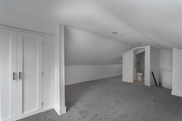 bonus room with carpet floors, a textured ceiling, and vaulted ceiling