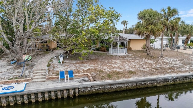 rear view of property featuring a gazebo and a water view