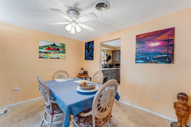 carpeted dining room with ceiling fan