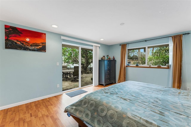 bedroom featuring multiple windows, hardwood / wood-style flooring, and access to exterior