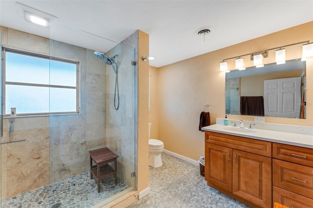 bathroom featuring vanity, toilet, and walk in shower