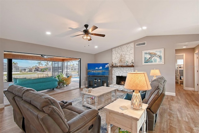 living room with ceiling fan, light wood-type flooring, and lofted ceiling