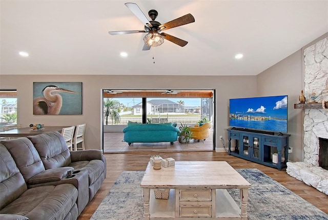 living room with ceiling fan, a healthy amount of sunlight, a fireplace, and light hardwood / wood-style flooring