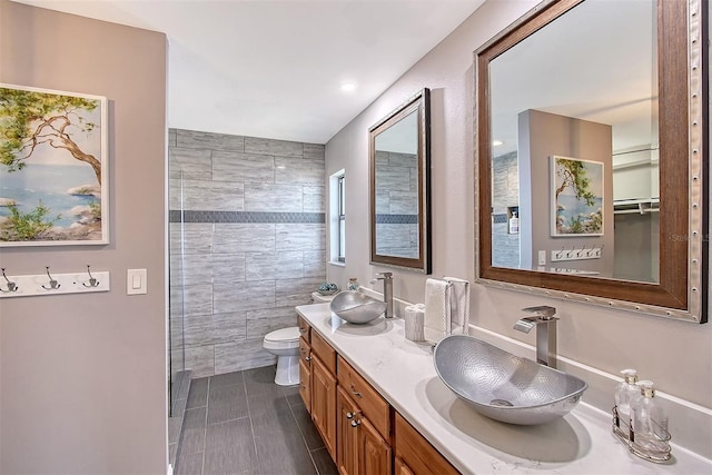 bathroom with tile patterned floors, vanity, toilet, and tile walls