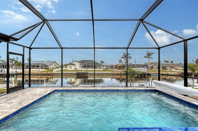 view of swimming pool with glass enclosure, a water view, and a patio