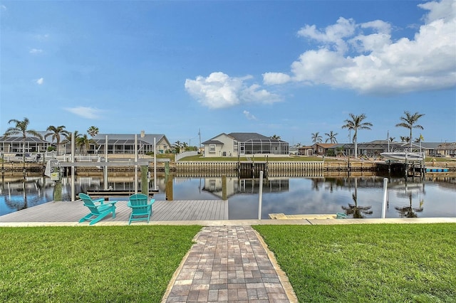 view of dock with a lawn and a water view