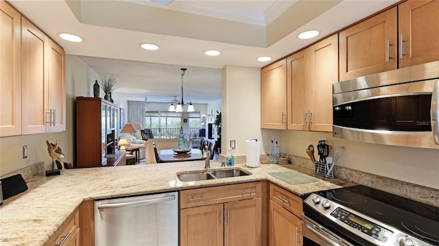 kitchen with sink, light brown cabinets, kitchen peninsula, appliances with stainless steel finishes, and ornamental molding