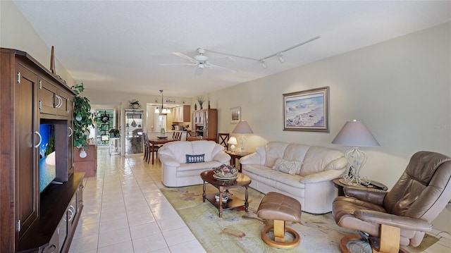 living room featuring a textured ceiling, ceiling fan, light tile patterned flooring, and rail lighting