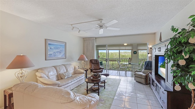 living room featuring ceiling fan, light tile patterned floors, rail lighting, and a textured ceiling