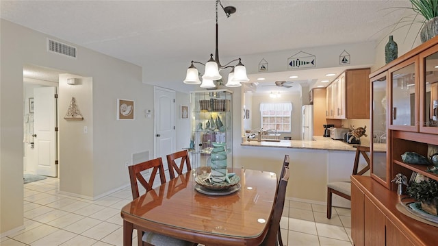 dining room with light tile patterned floors and an inviting chandelier