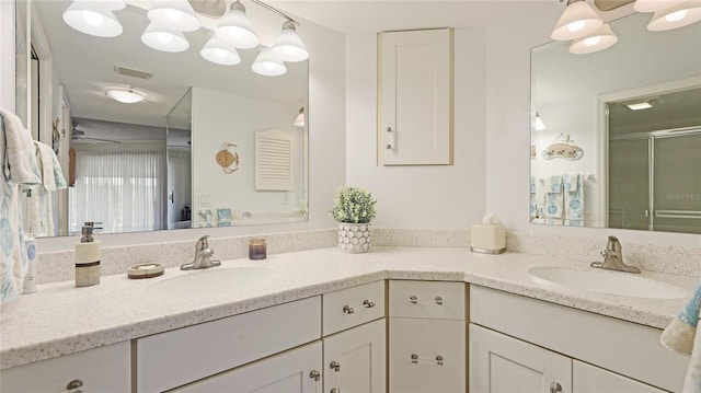 bathroom with vanity, ceiling fan, and a shower with shower door