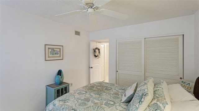 bedroom with a textured ceiling, a closet, and ceiling fan