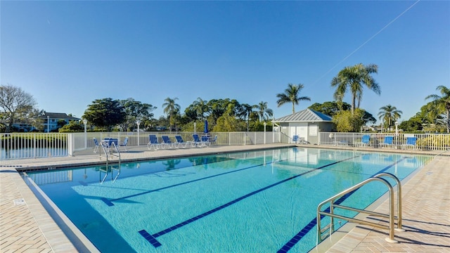 view of swimming pool with a water view and a patio area