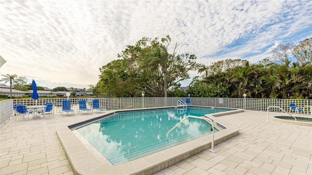 view of pool featuring a patio and a hot tub